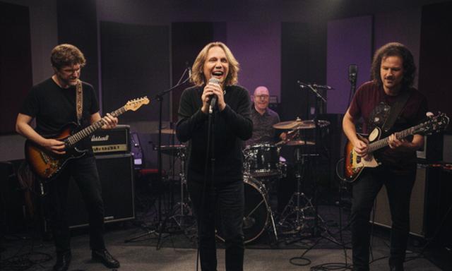 Rockcoverband die live-in-studio speelt met zanger en gitaristen onder studiolampen